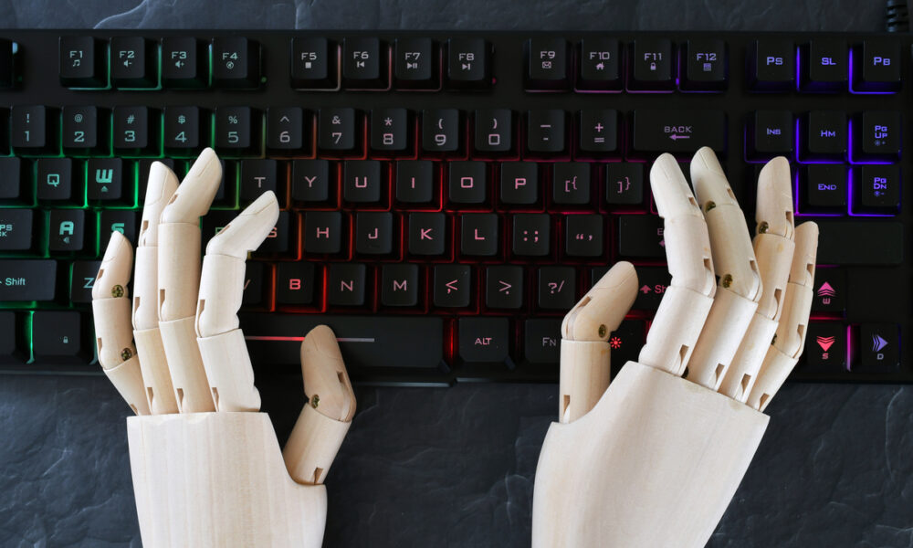 Mãos de robô digitando em teclado; conceito de inteligência artificial, IA