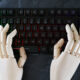 Mãos de robô digitando em teclado; conceito de inteligência artificial, IA