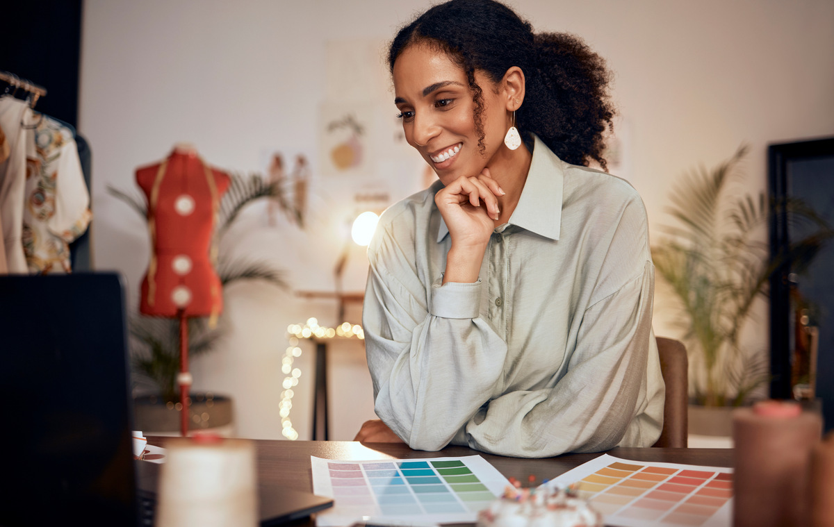 mulher negra sorrindo com manequim atrás; e-commerces