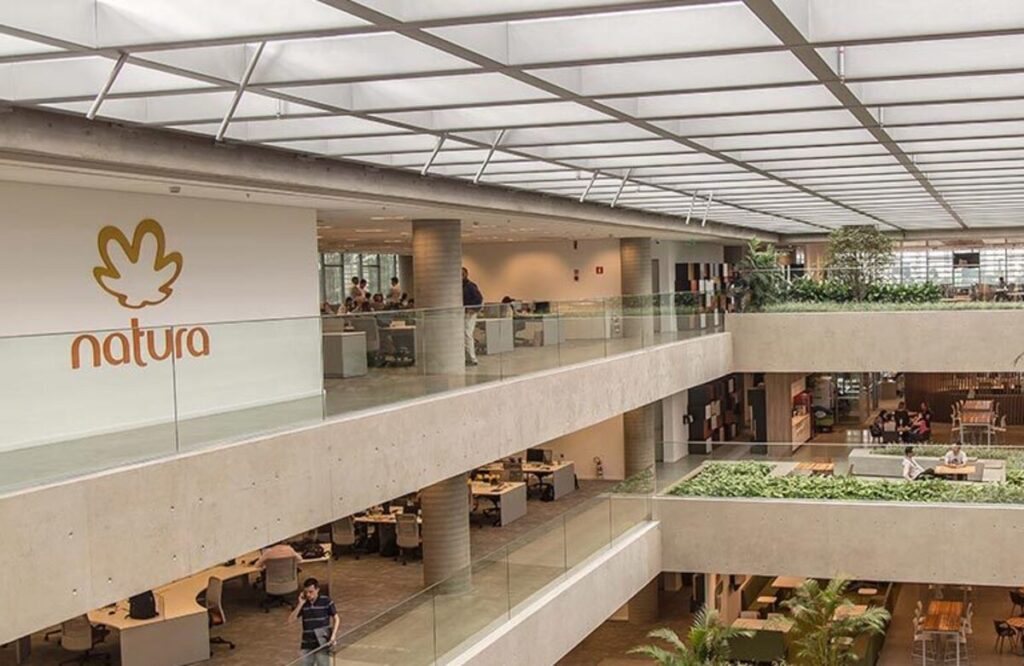 Escritório da empresa Natura, com andares e a logo da marca na parede.