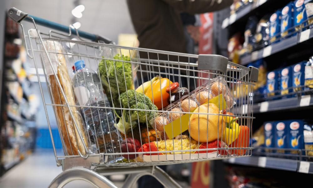 Pessoa fazendo compras em supermercado; consumo em supermercados