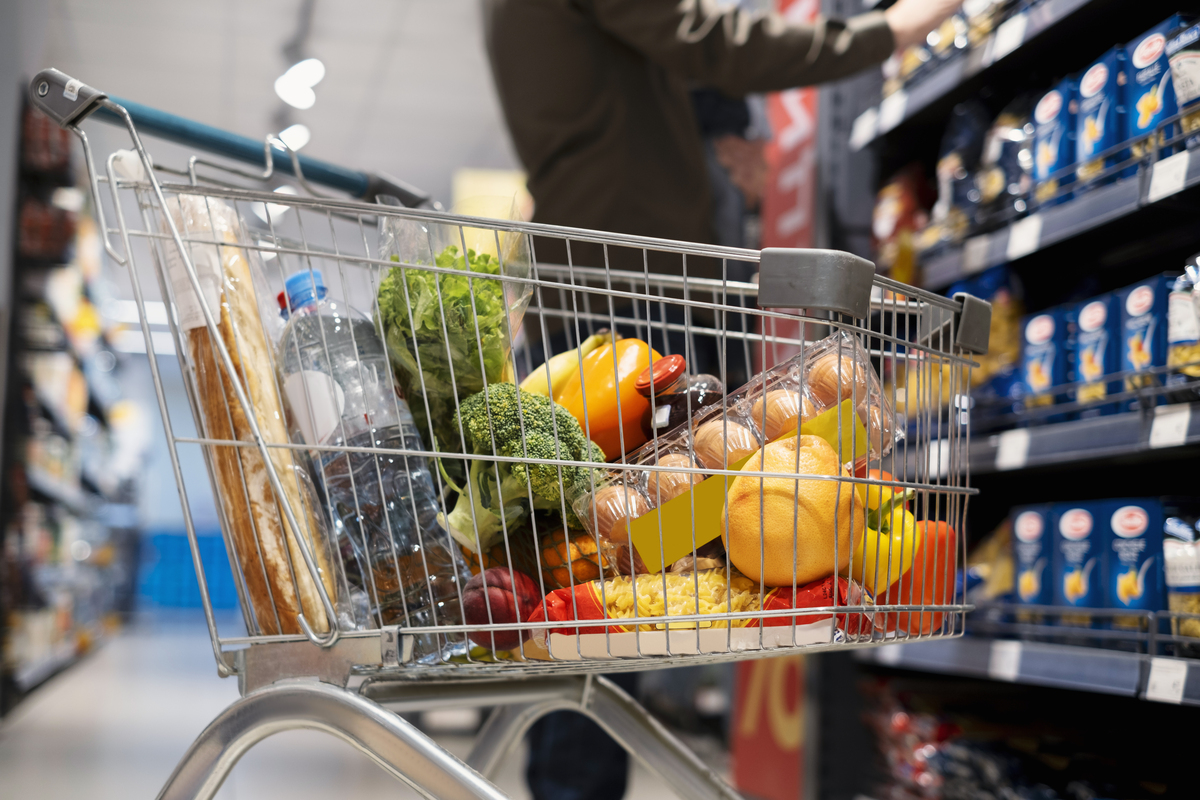 Pessoa fazendo compras em supermercado; consumo em supermercados