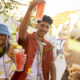 Pessoas comemorando o carnaval com copos de bebida nas mãos