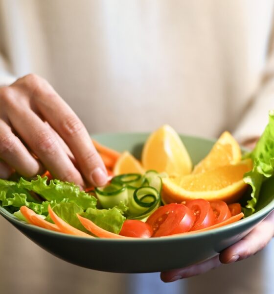 Pessoa organizando prato de salada; vegetarianismo; saudável; desperdício de alimentos