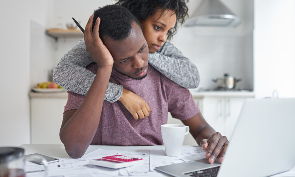 marido e esposa abraçados com dificuldade de pagar contas; dívidas, inadimplência das famílias
