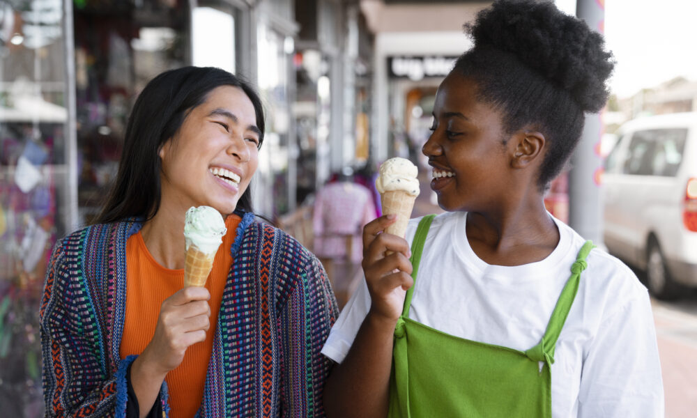 mulheres tomando sorvetes na rua; consumo de sorvetes