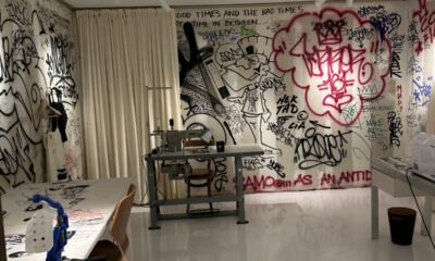 Foto da loja conceito Atelier Jolie, em Nova York, com paredes pixadas intencionalmente e máquina de costura.