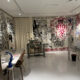 Foto da loja conceito Atelier Jolie, em Nova York, com paredes pixadas intencionalmente e máquina de costura.