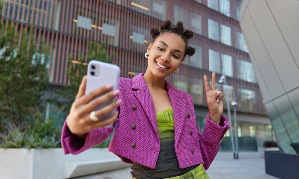 Mulher tira foto com seu celular; marketing de influência