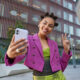 Mulher tira foto com seu celular; marketing de influência