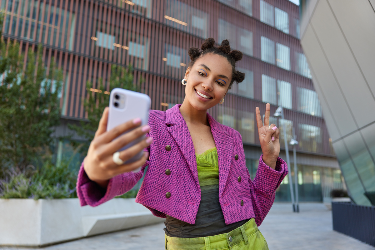 Mulher tira foto com seu celular; marketing de influência