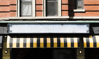 Fachada de uma loja com toldo em preto e amarelo