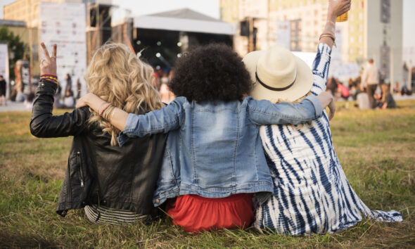 Mulheres abraçadas em festival de música
