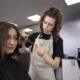 Mulher cortando o cabelo de outra no salão de beleza