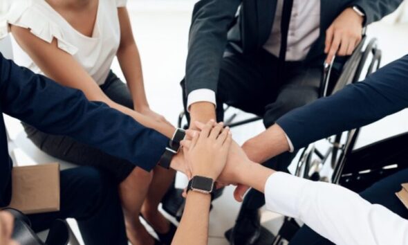 Mãos juntas de vários colaboradores com diversidade