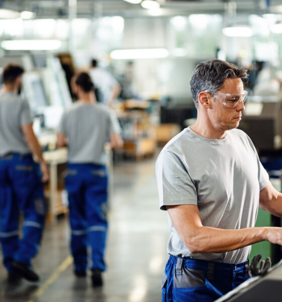 homem operando maquinário em indústria; produção industrial