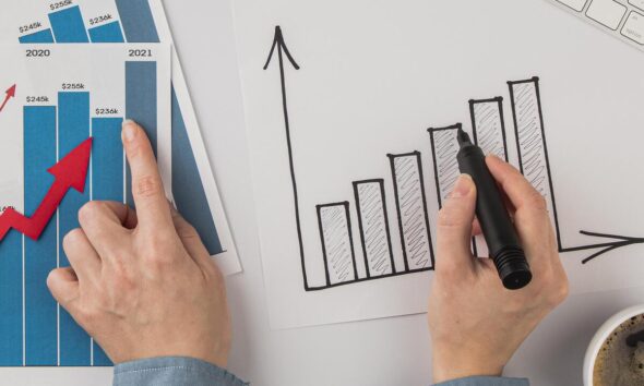 pessoa apontando gráficos em papel; conceito de forecast