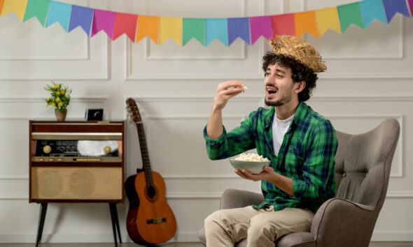 homem comendo pipoca em festa junina