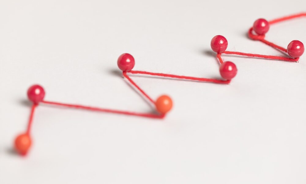 pinos ligados por fio vermelho, simbolizando jornada do cliente