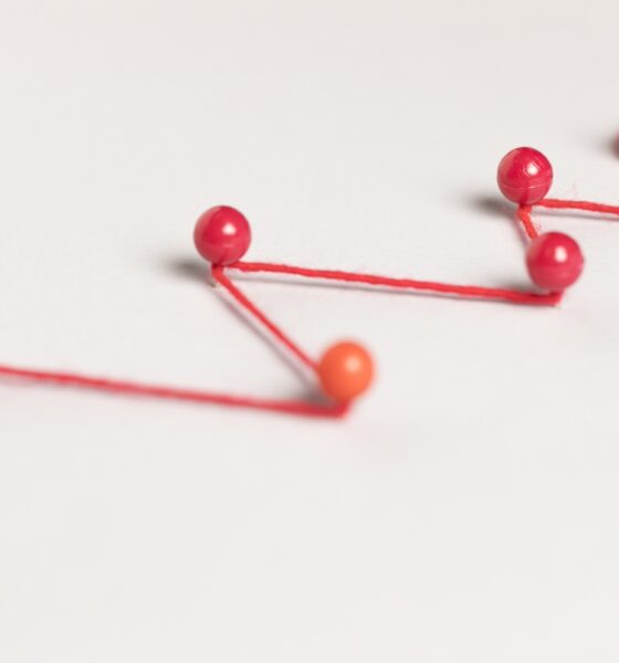 pinos ligados por fio vermelho, simbolizando jornada do cliente
