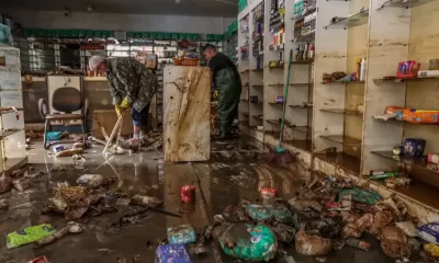 Pessoas limpando comércio depois de enchentes no Rio Grande do Sul