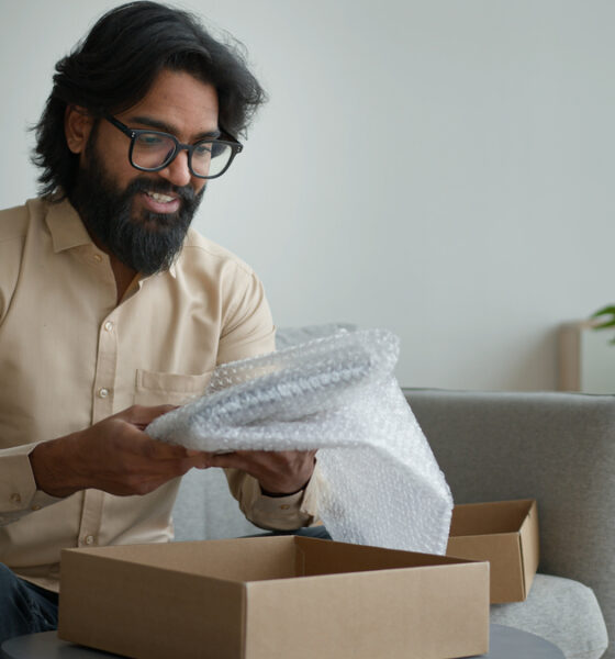 homem feliz abrindo caixa de serviço de assinatura; customer success; experiência pós-compra; dia do consumidor