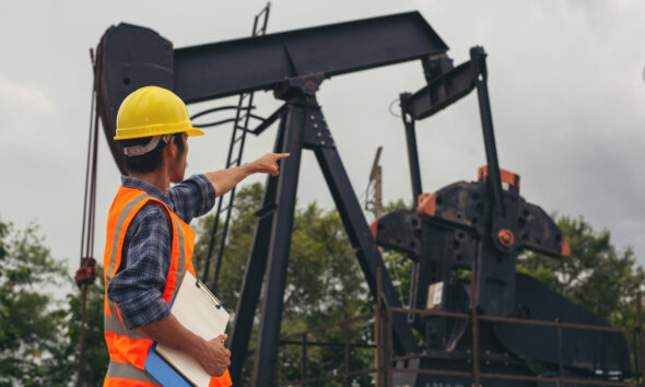 Homem trabalhando na produção industrial de petróleo; jornada 4x3