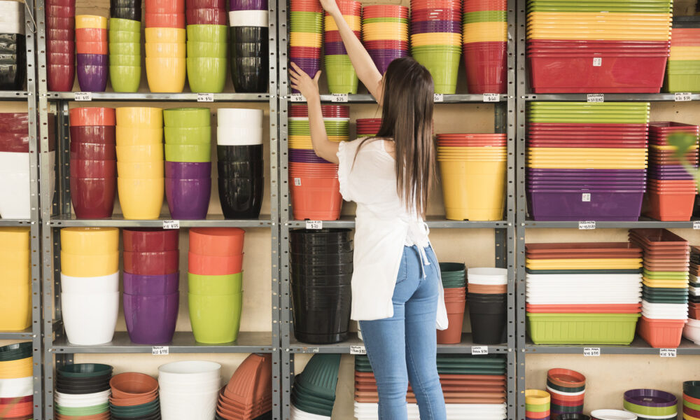 mulher em loja de artigos para casa, pegando vasos de planta