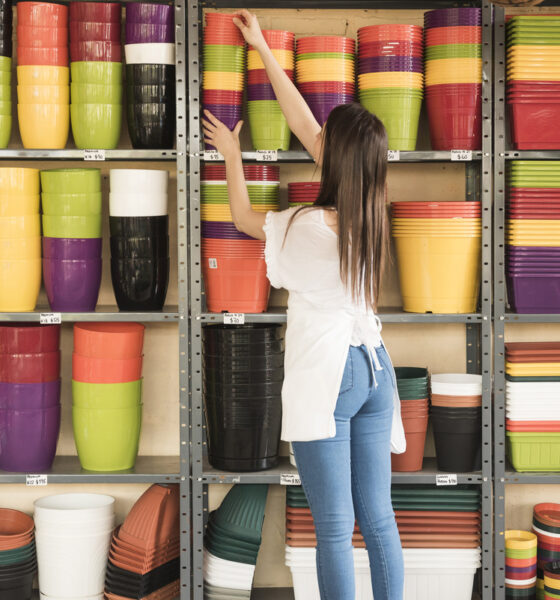 mulher em loja de artigos para casa, pegando vasos de planta