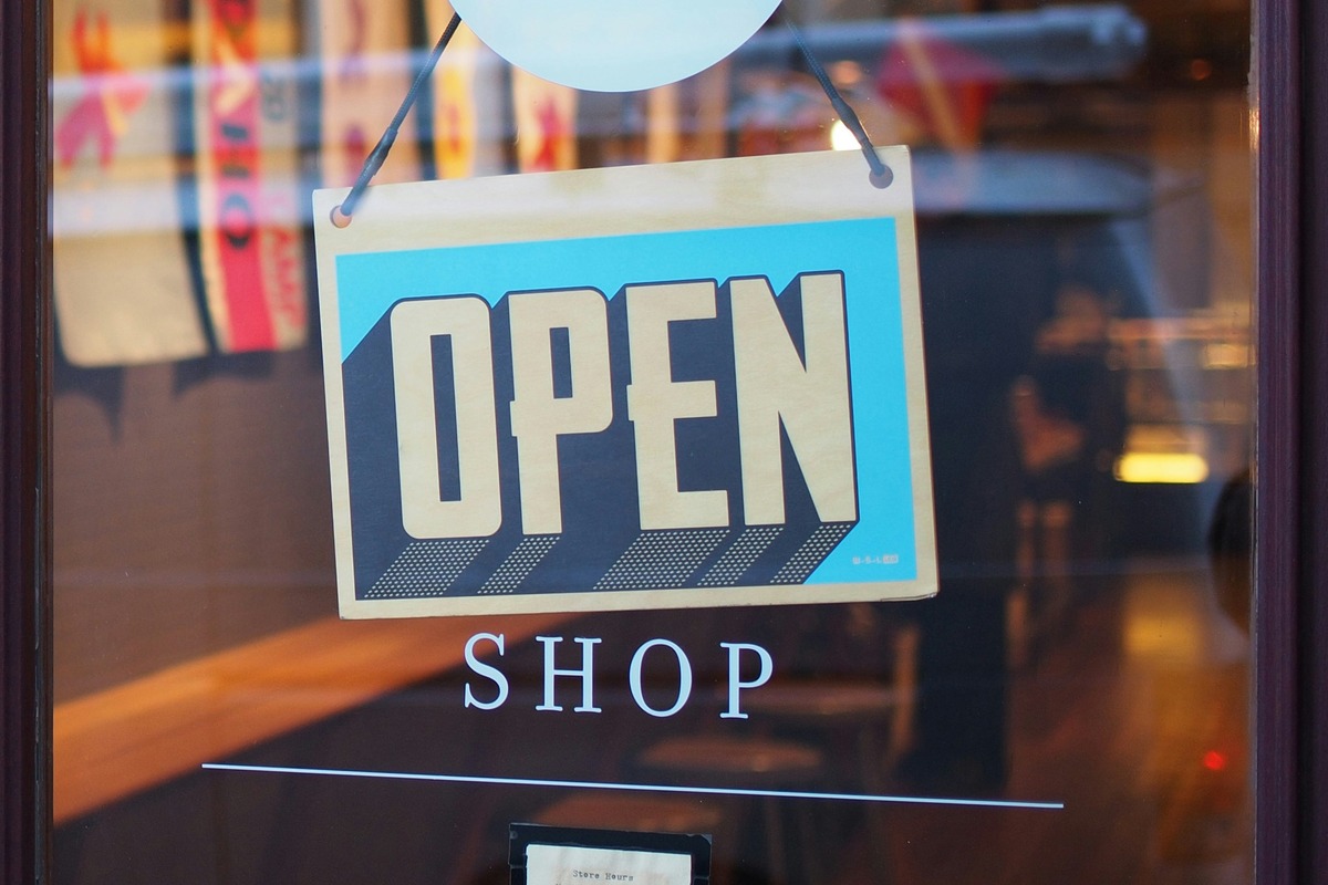 Fachada de loja com placa "Open Shop"