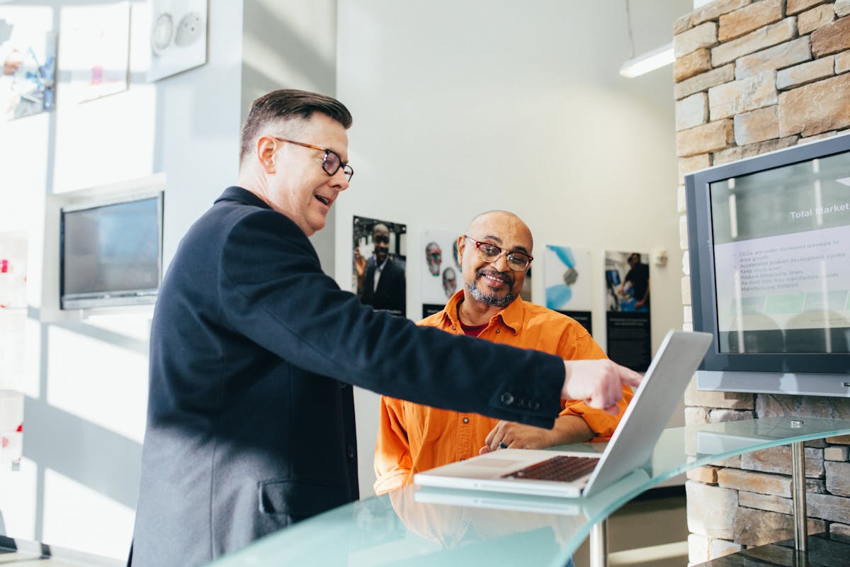 Vendedor mostrando algo para cliente no computador